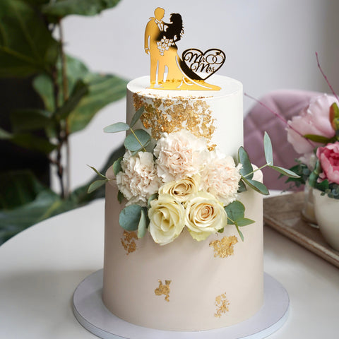 Elegante Hochzeitstorte mit goldenem Brautpaar-Topper