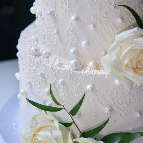 Elegante Hochzeitstorte mit Perlen und weißen Rosen