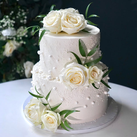 Elegante Hochzeitstorte mit Perlen und weißen Rosen