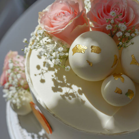 Torte mit frischen Blumen und Schokokugeln